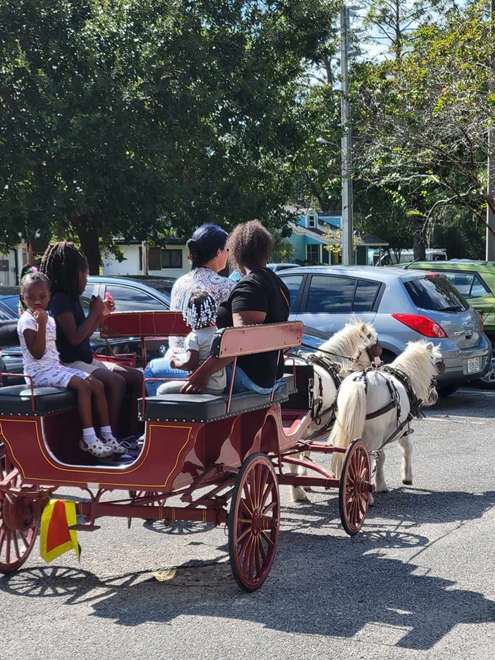 Our Lil Red Wagon giving carriage rides at a festival at a senior living facility in Jacksonville Beach, FL.