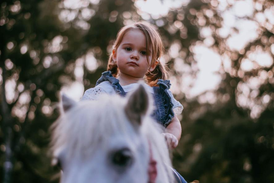 A cute little cowgirl is enjoying a ride on our pony Smokey in St. Augustine, FL.